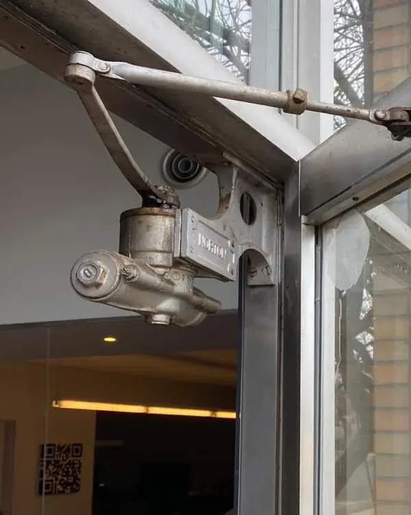 A door closer on a glass and aluminum storefront door