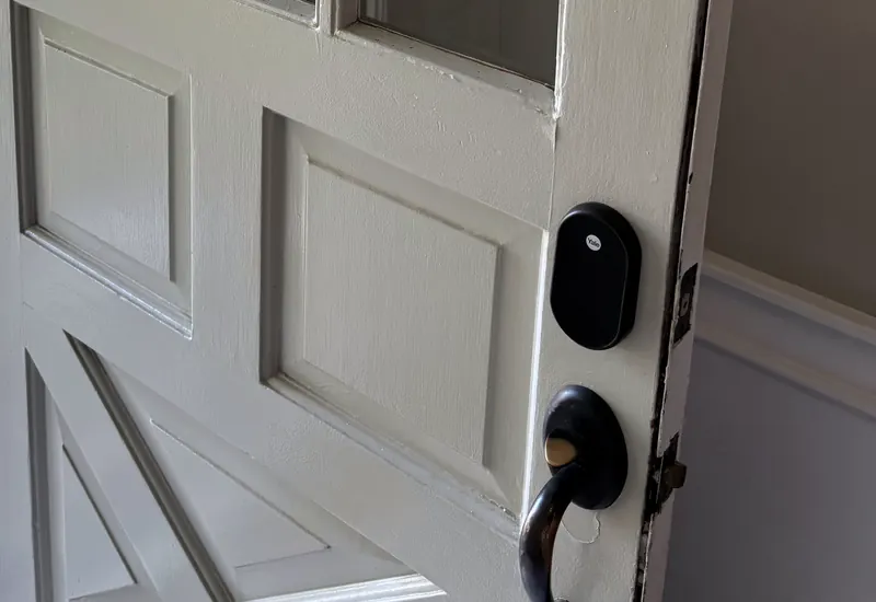 A smart deadbolt and lever handle on a white entry door