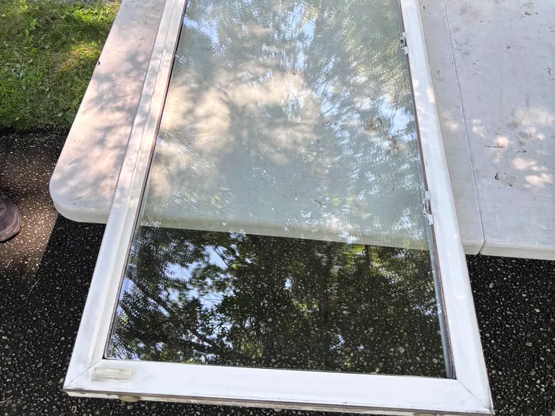 A window sash with new glass lying on a work table