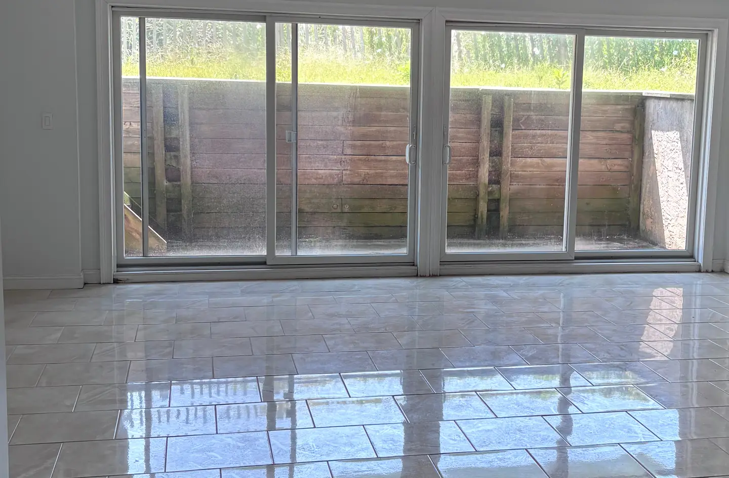 Two sliding patio doors in an empty finished basement room