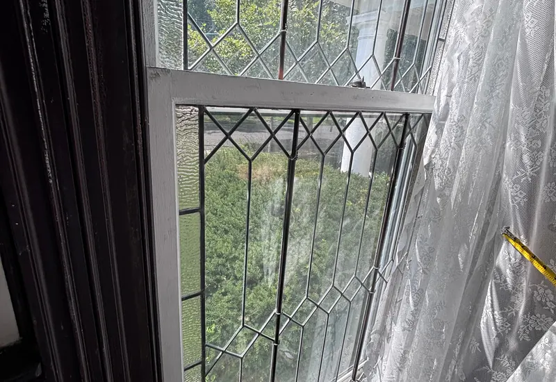 A leaded glass window panel with a diamond pattern