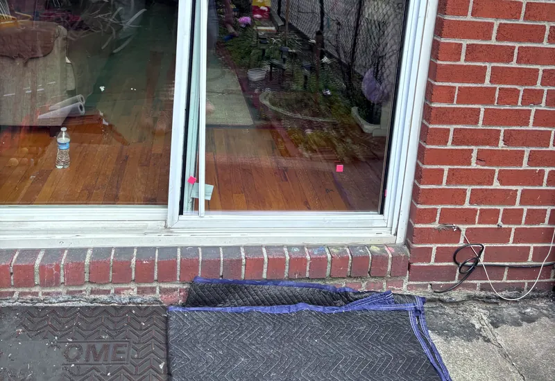 The lower part of a sliding patio door in a brick wall