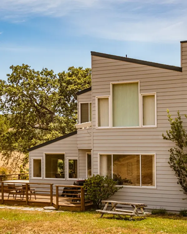 A contemporary house with large windows above a deck
