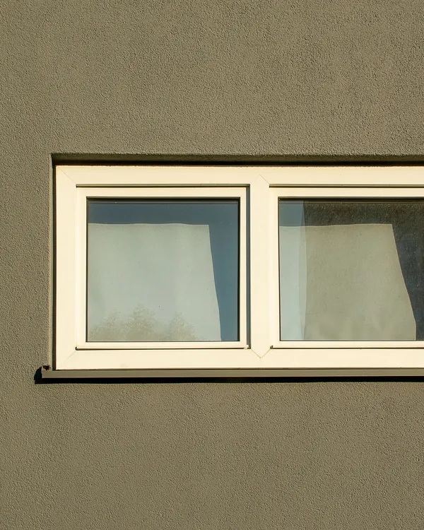 A horizontal sliding window in a painted wall