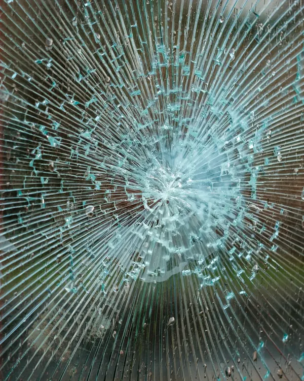 A shattered glass pane held together by its interlayer