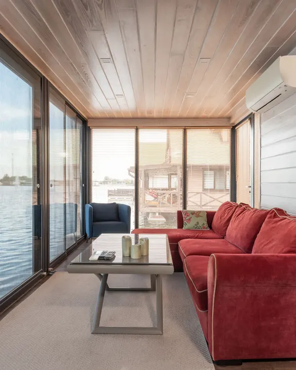 A room with a wall of multi slide glass doors facing the water