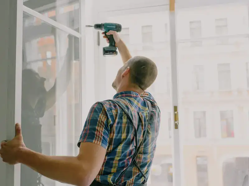 An installer fastening a new window into its opening