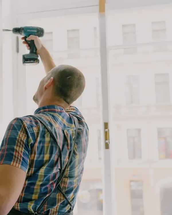 An installer fastening a new window into its opening