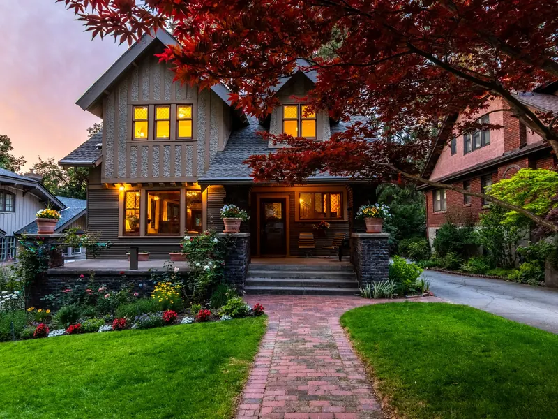 A craftsman house with lit windows at dusk