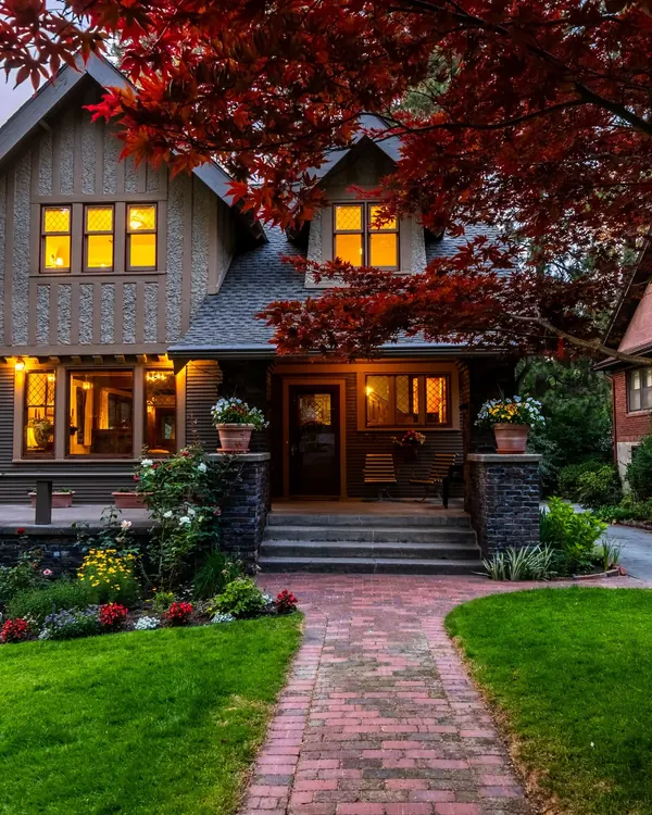 A craftsman house with lit windows at dusk