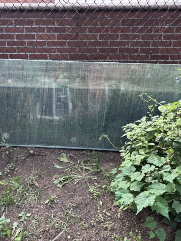 Removed insulated glass unit standing against a brick wall