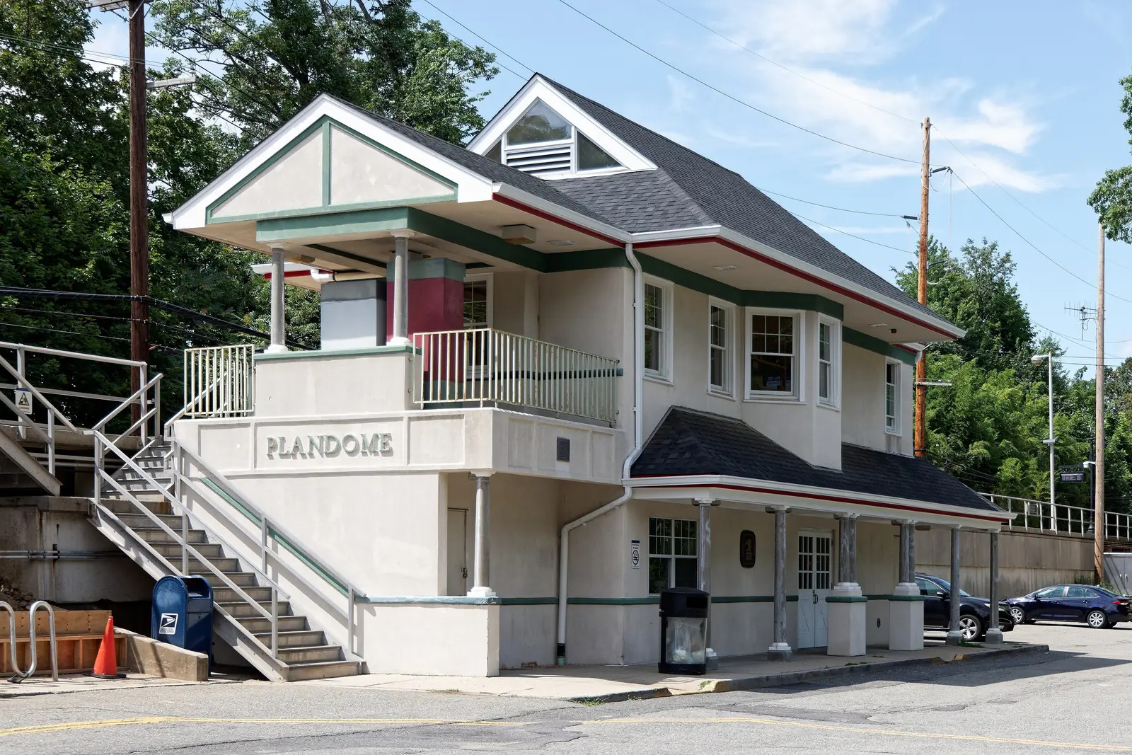 Plandome train station house, a cream building with green trim and a PLANDOME sign, in Plandome, NY