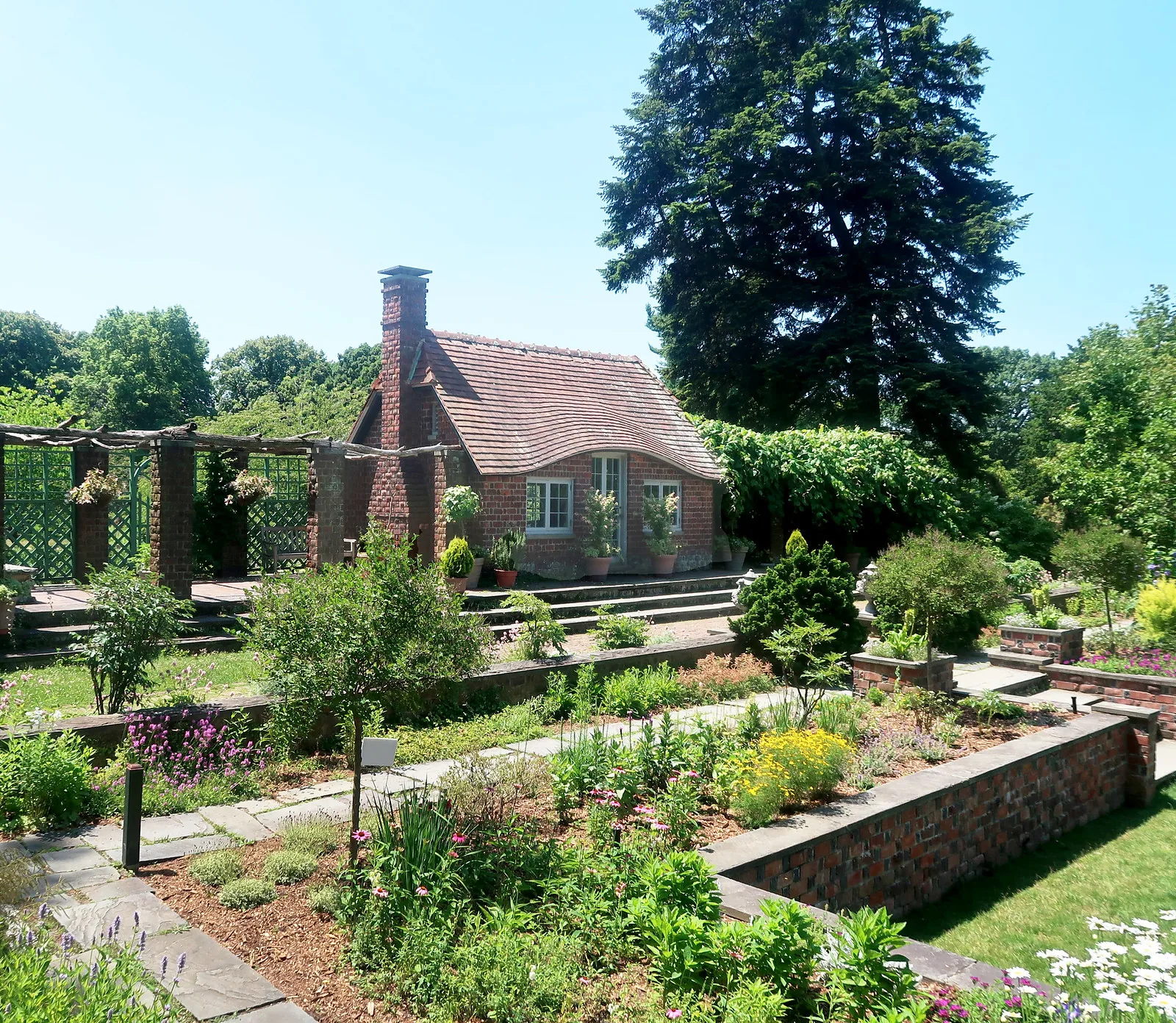 Brick garden cottage above planted terraces at Planting Fields Arboretum in Upper Brookville, NY