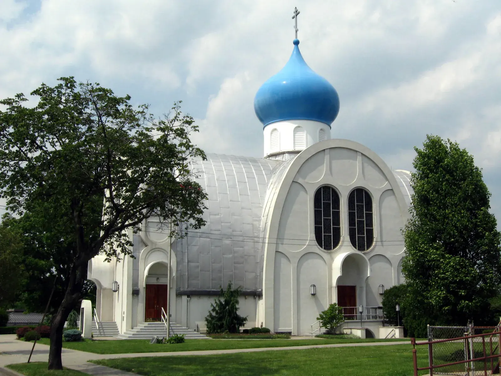 St. Nicholas Russian Orthodox Church in Whitestone with its bright blue onion dome above a white church and a green lawn